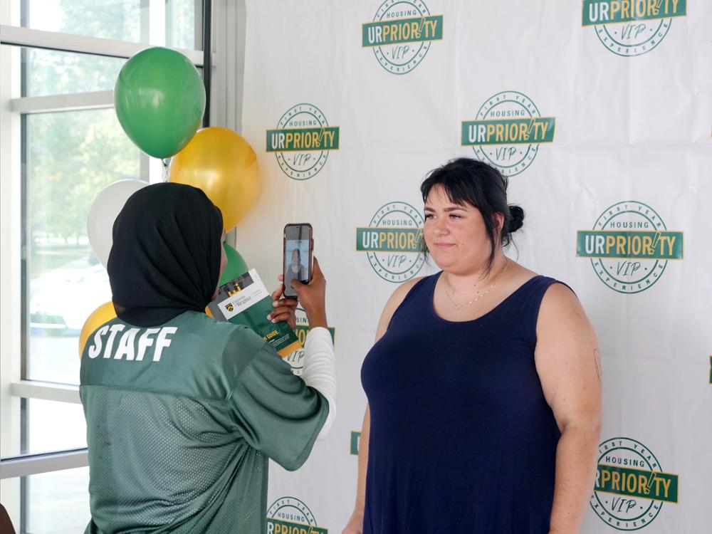 A student poses for a photo from a volunteer on move-in day