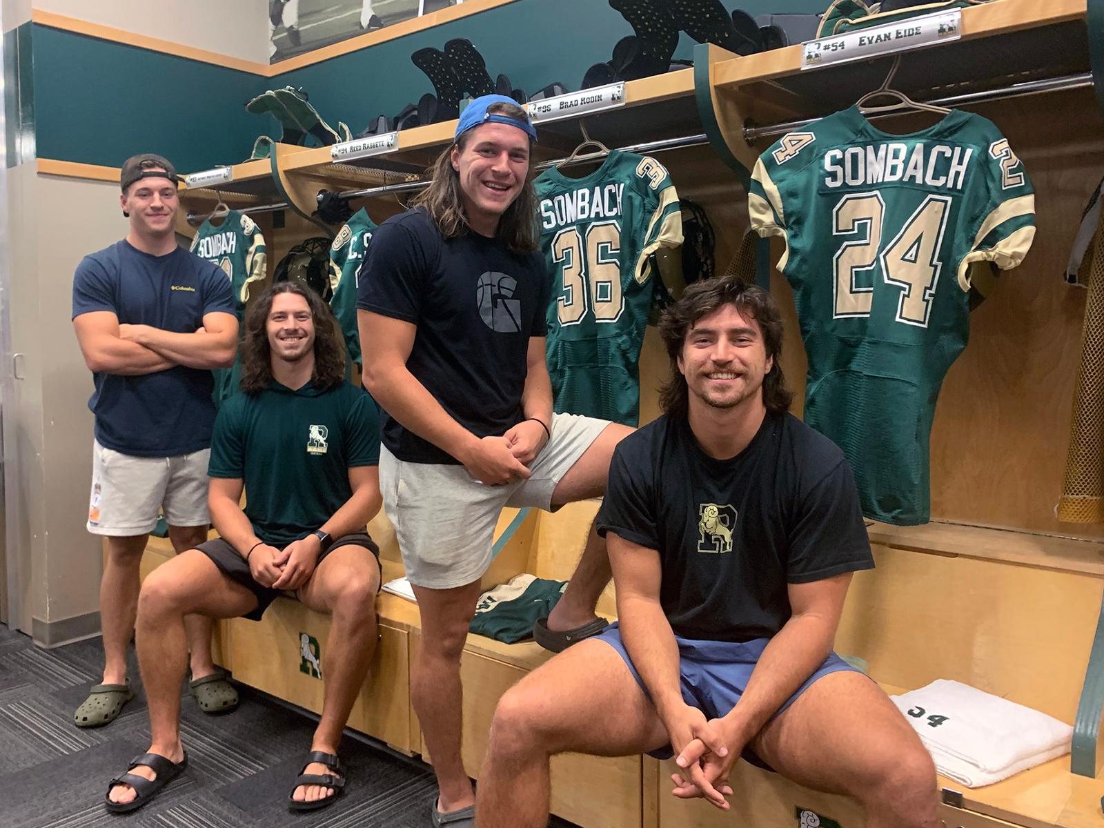 Four football players in a locker room