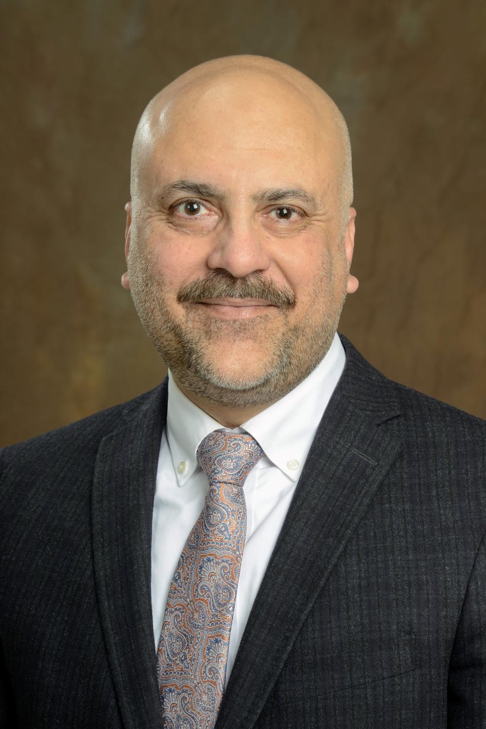 A smiling man in a suit and tie