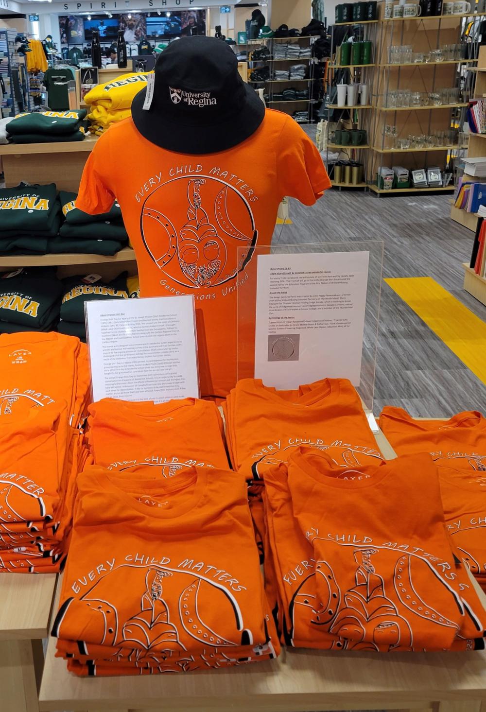 Several bright orange t-shirts with the words EVERY CHILD MATTERS and graphic image on display