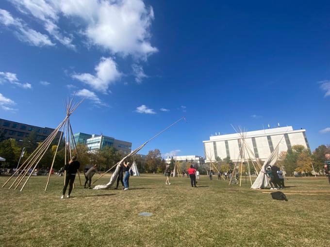 Team members assembling tipis