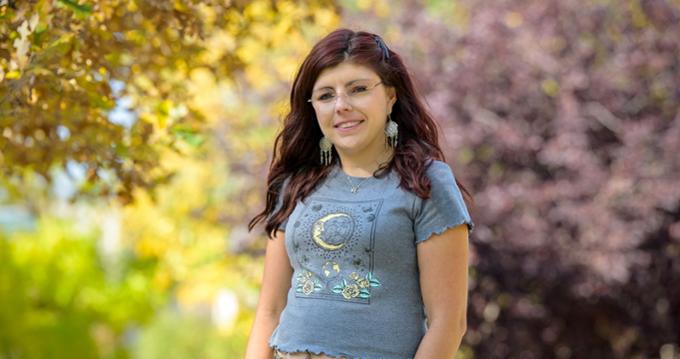 Student posing in front of trees