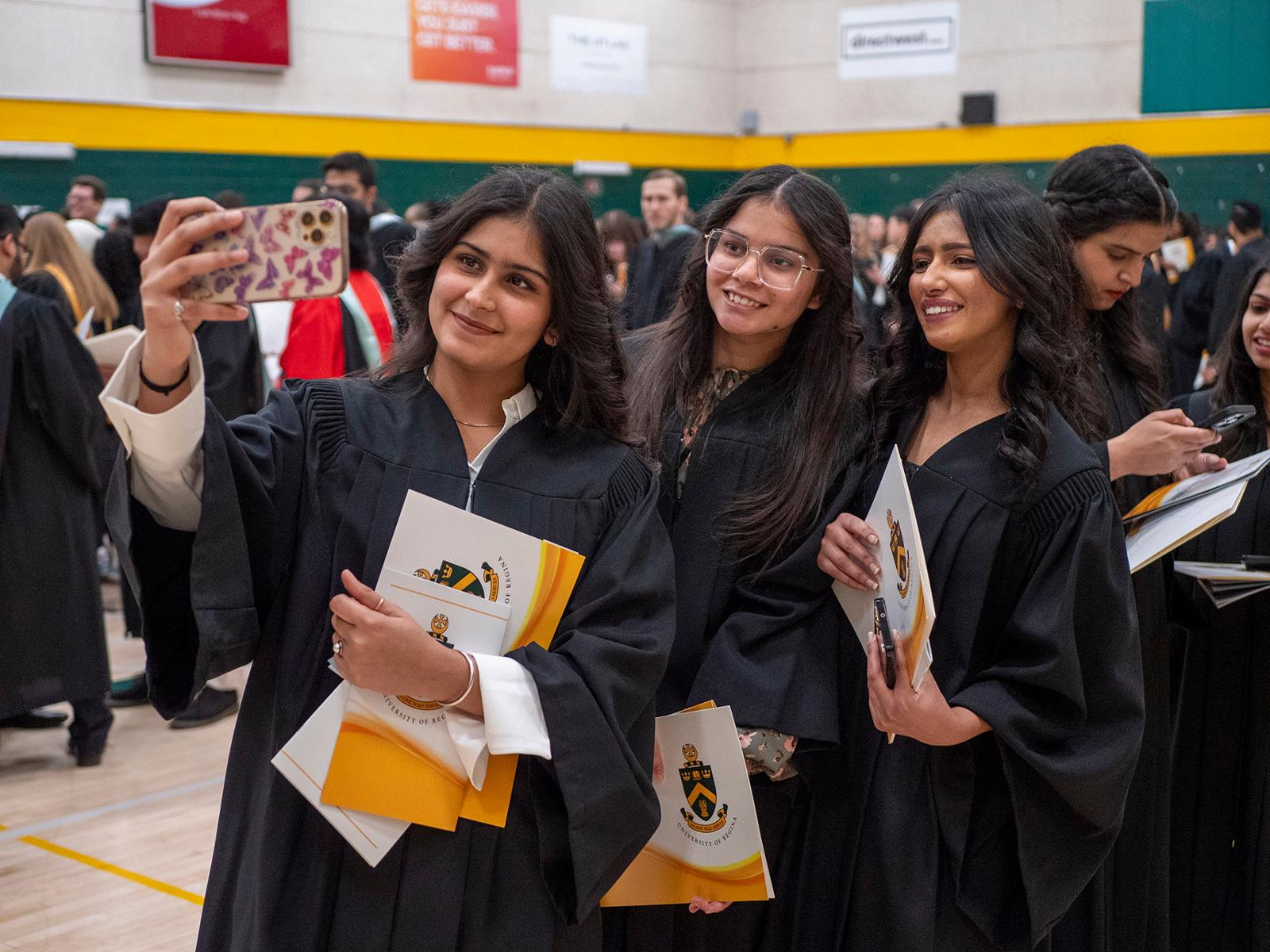three graduating students take a selfie at convocation
