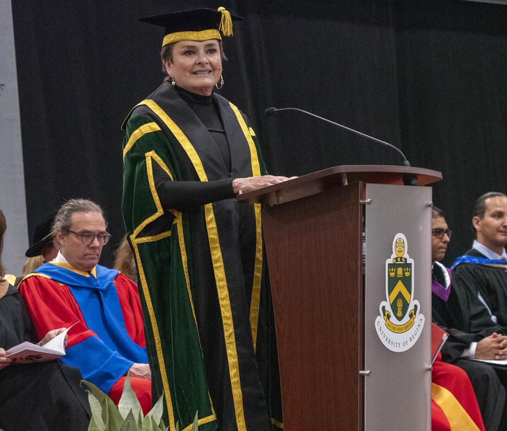 A woman on stage, speaking at a podium