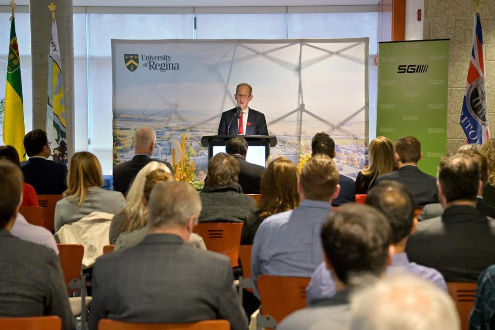 Individual speaking to a crowd of seated people.