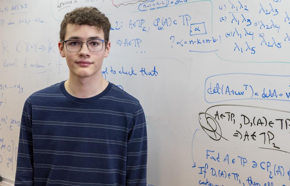 Individual standing in front of a white board.