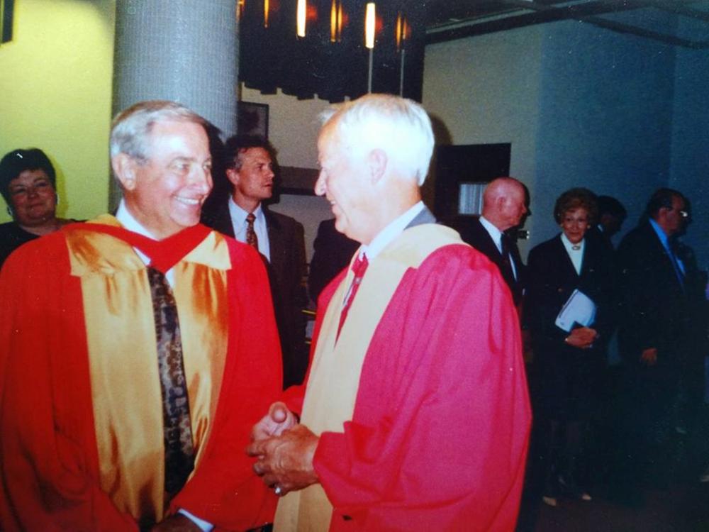 Two older men dressed in regalia.