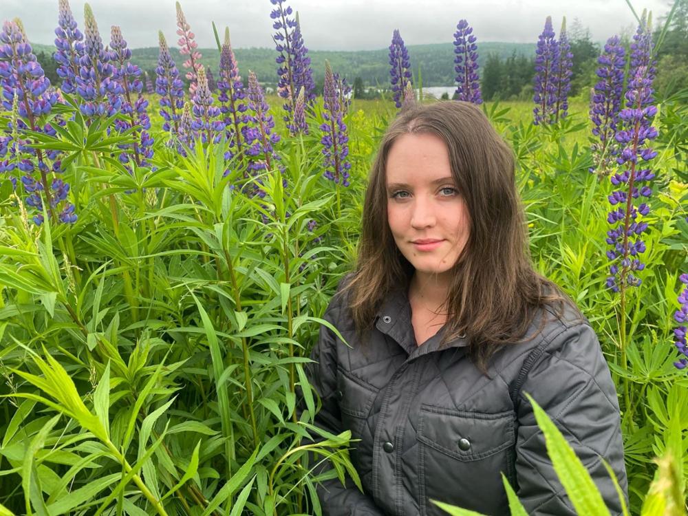 : Individual in a field, surrounded by plants.