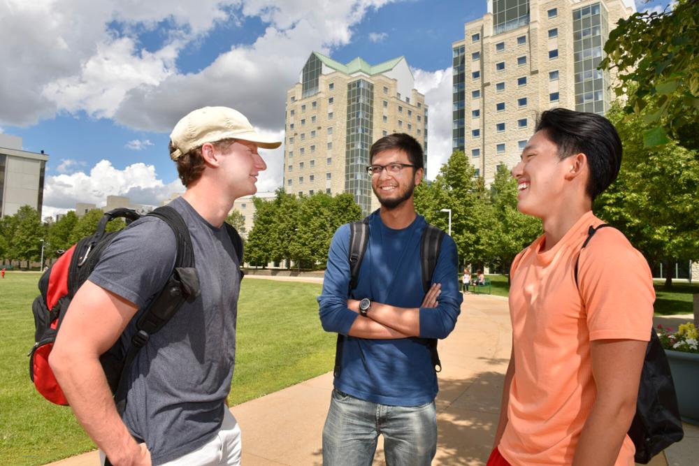 Three students standing outdoors.