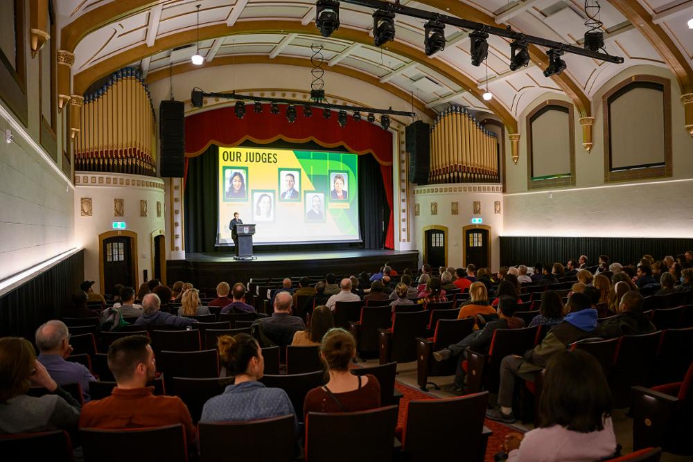 A room of people watching a presentation