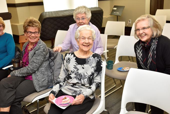 A group of senior citizens celebrating the birthday of a 100-year old student.