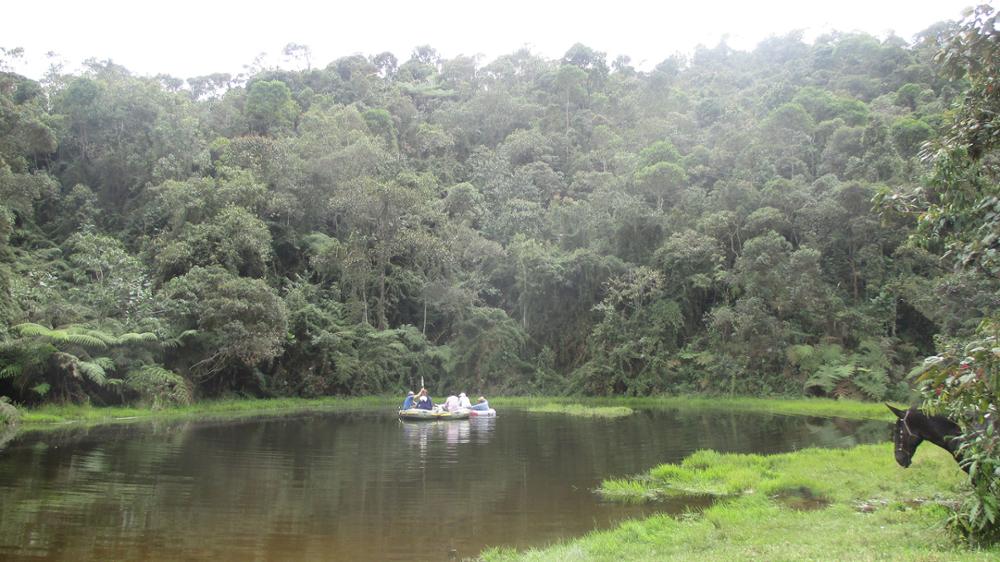 Professor and students in boat in Columbia taking core samples from the lakebed.