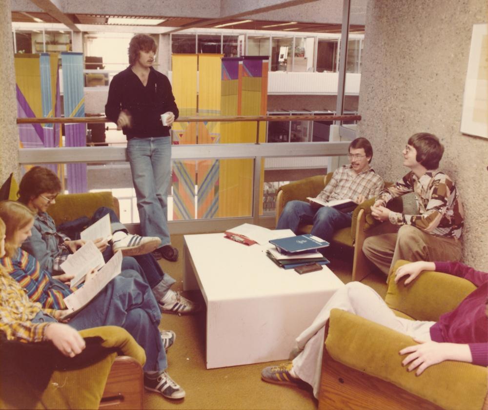 Individuals sitting around a coffee table and studying.