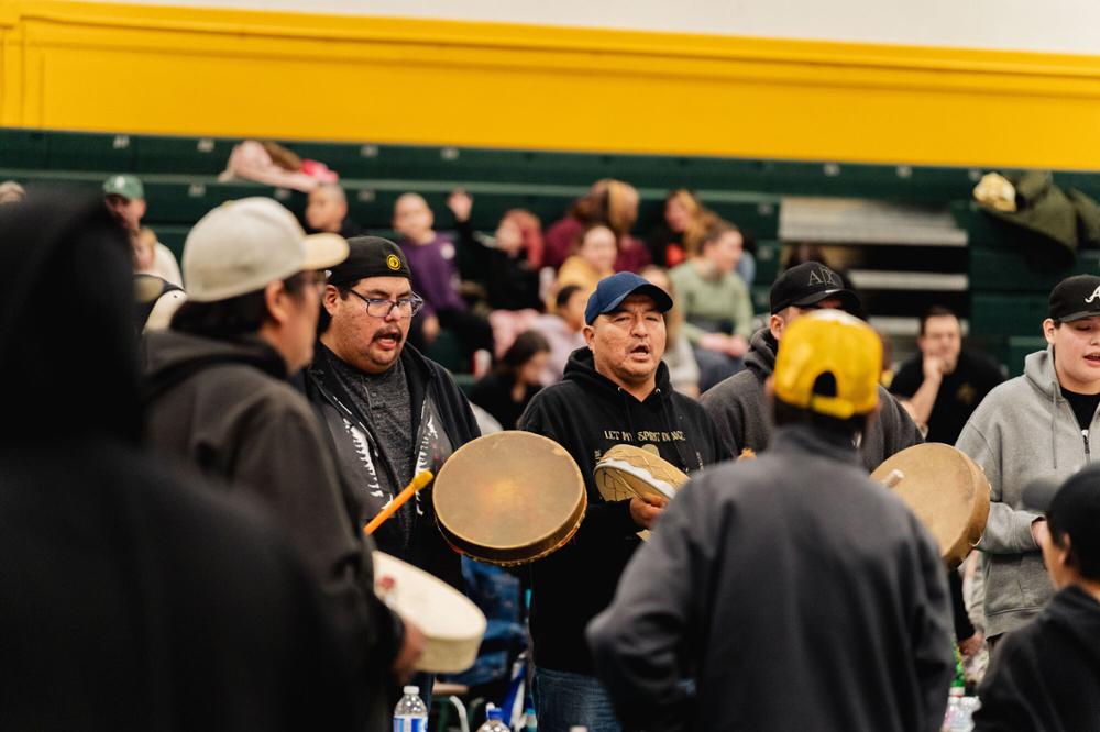 Indigenous drum circle with people watching