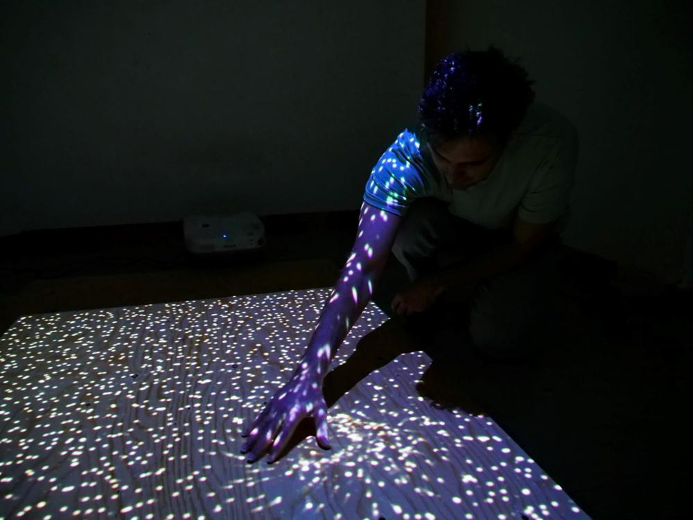 a student demonstrating a project in a darkened room