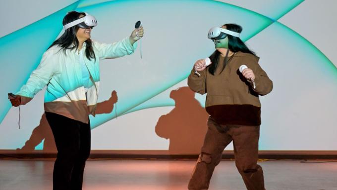 two students use laser lights in a darkened room