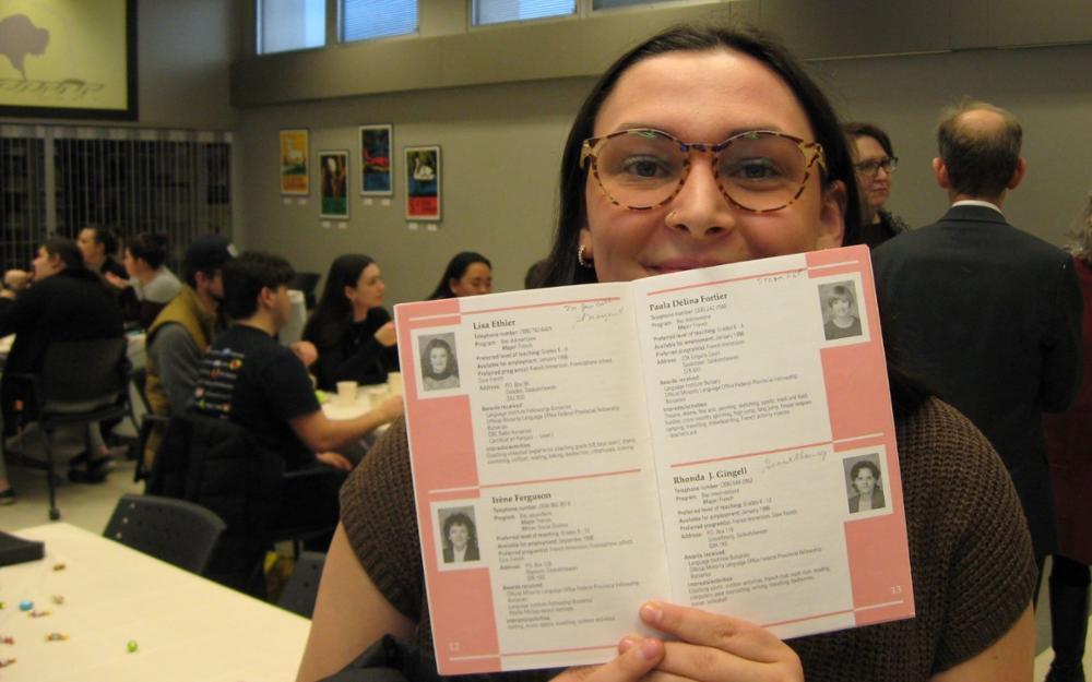 A person sitting, holding a card