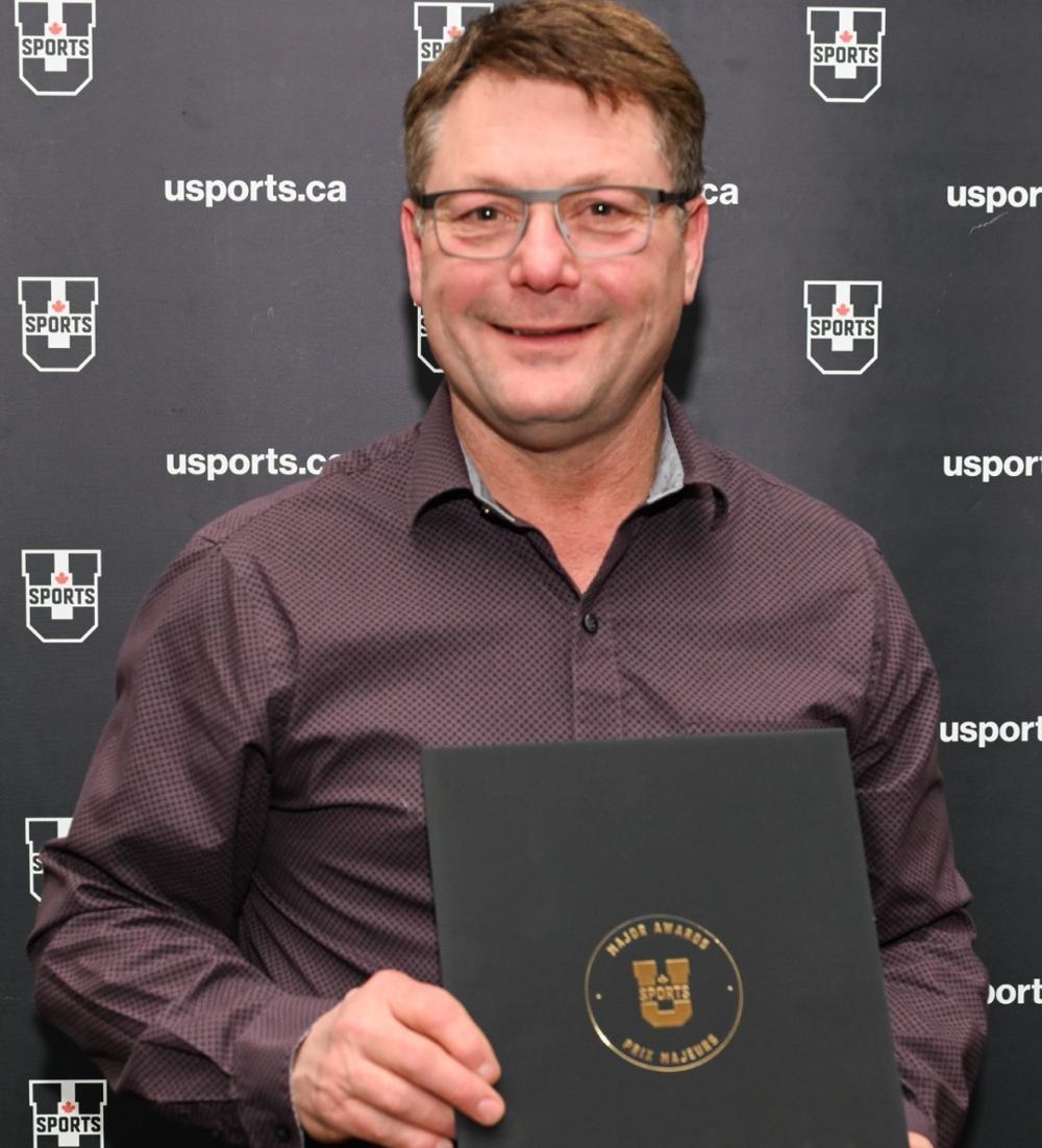 Smiling man holding award envelope