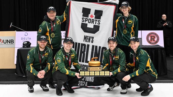 Six men in U of R curling team uniforms hold U SPORTS banner and trophy