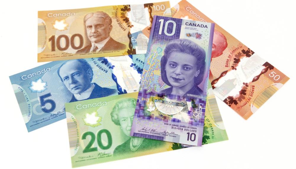 Five different Canadian dollar bills in different denominations and colours.