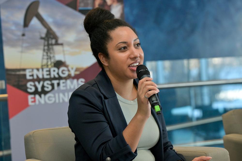 A close up of an individual with a microphone speaking at an event.