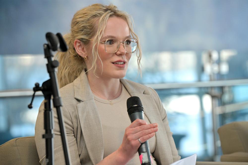 A close up of an individual with a microphone speaking at an event.