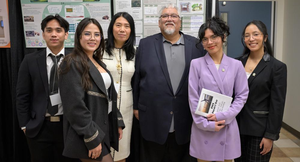 A group of individuals stands in front of a project board.