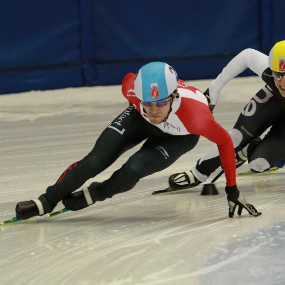 Speed skater leans into the turn at competition