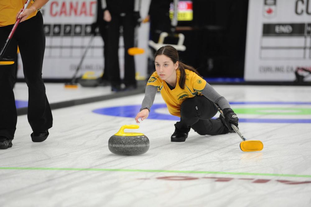 Curler throws rock in competition.