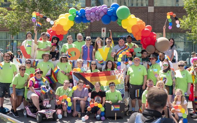 Many people celebrating in a park with colourful balloons