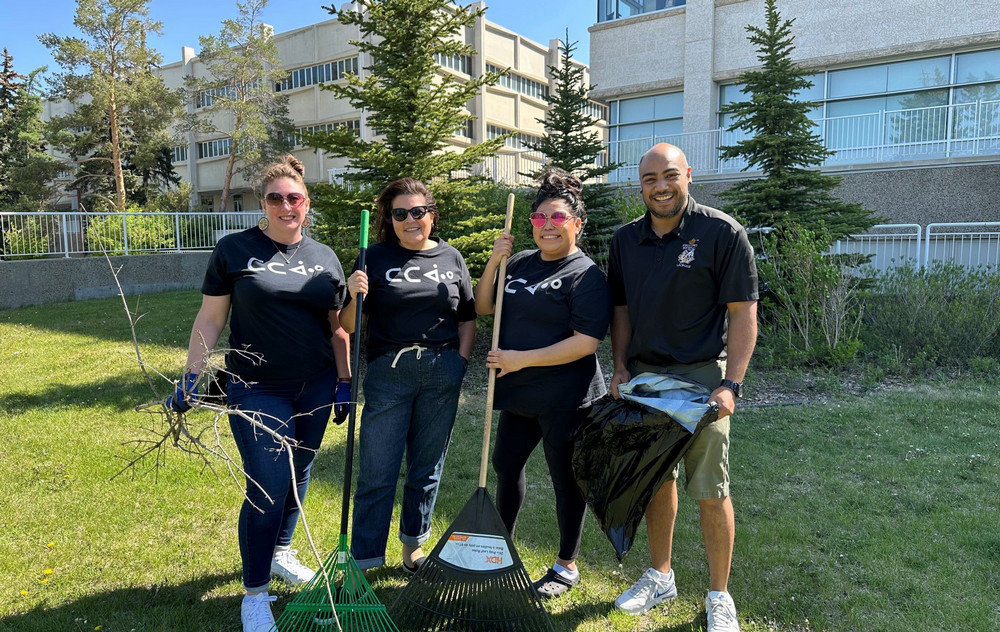 4 people holding rakes and shovels