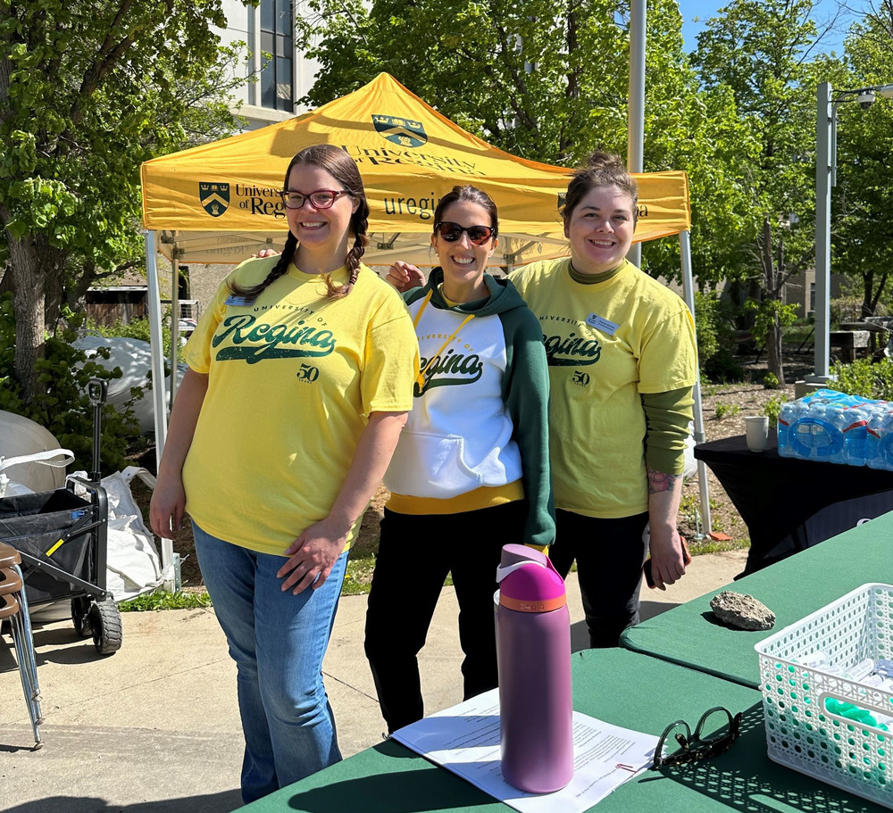 three people standing beside a table