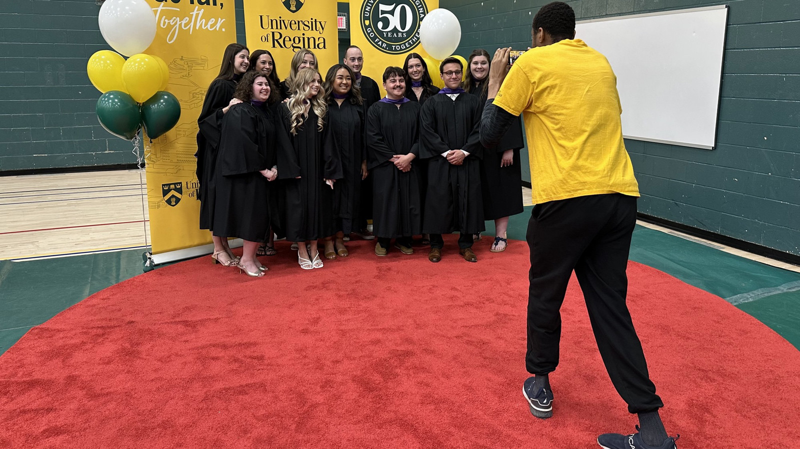 a group of students getting their picture taken at convocation