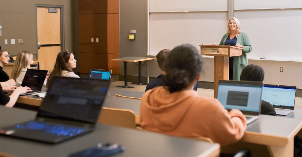 a speaker and students in a lecture hall
