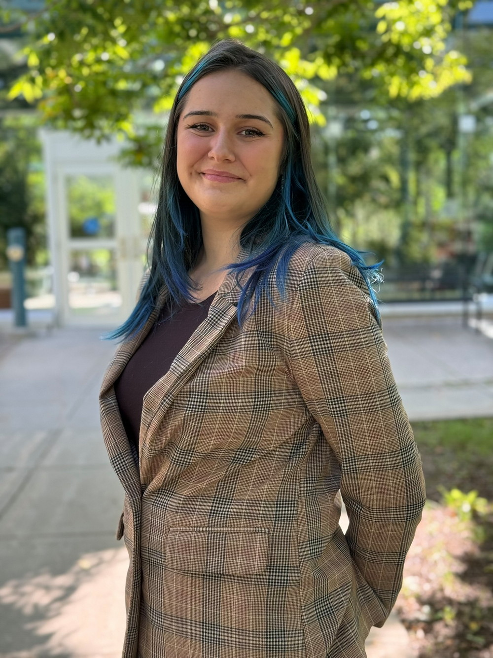 A young woman stands confidently at an outside location