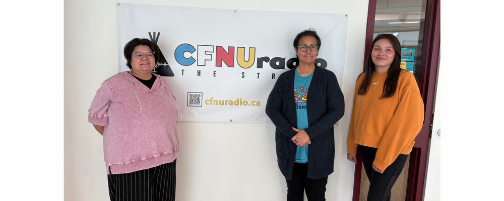 Three individuals standing in front of a sign that reads “CFNU radio”.