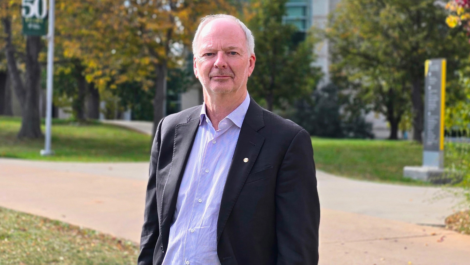 a man standing outside on campus