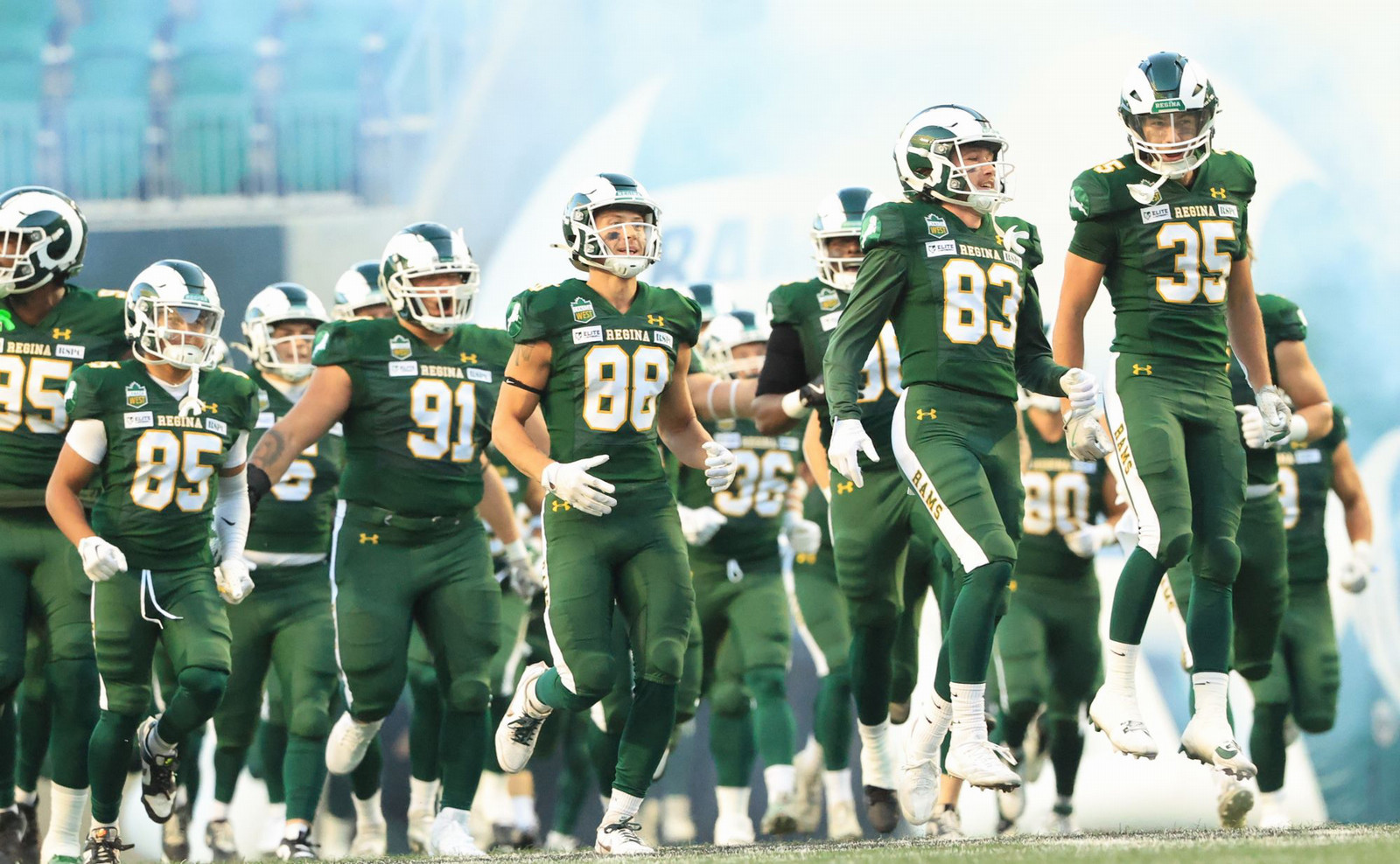 several football players running onto the field