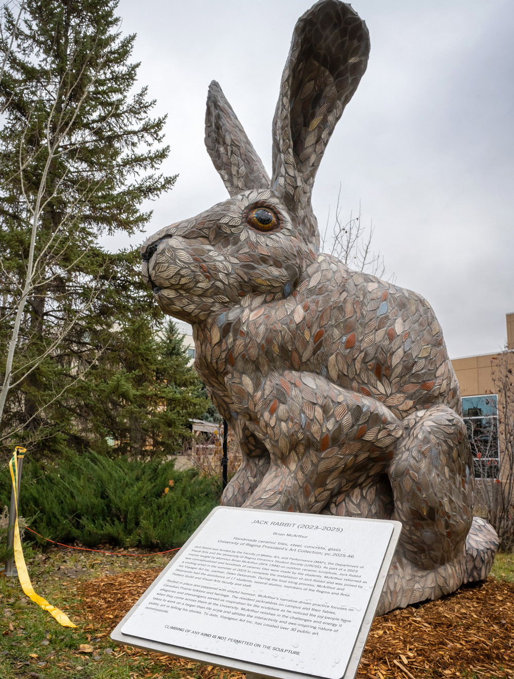 a large rabbit sculpture with plaque in foreground
