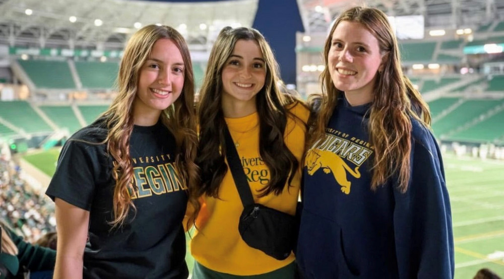 three people standing in a stadium