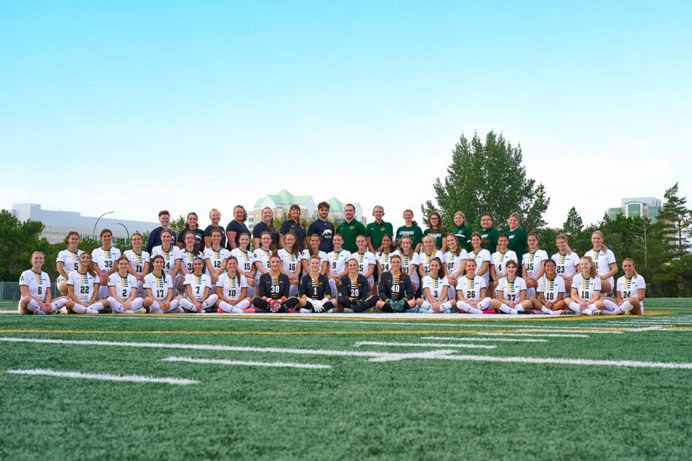 a team posing on a grass field