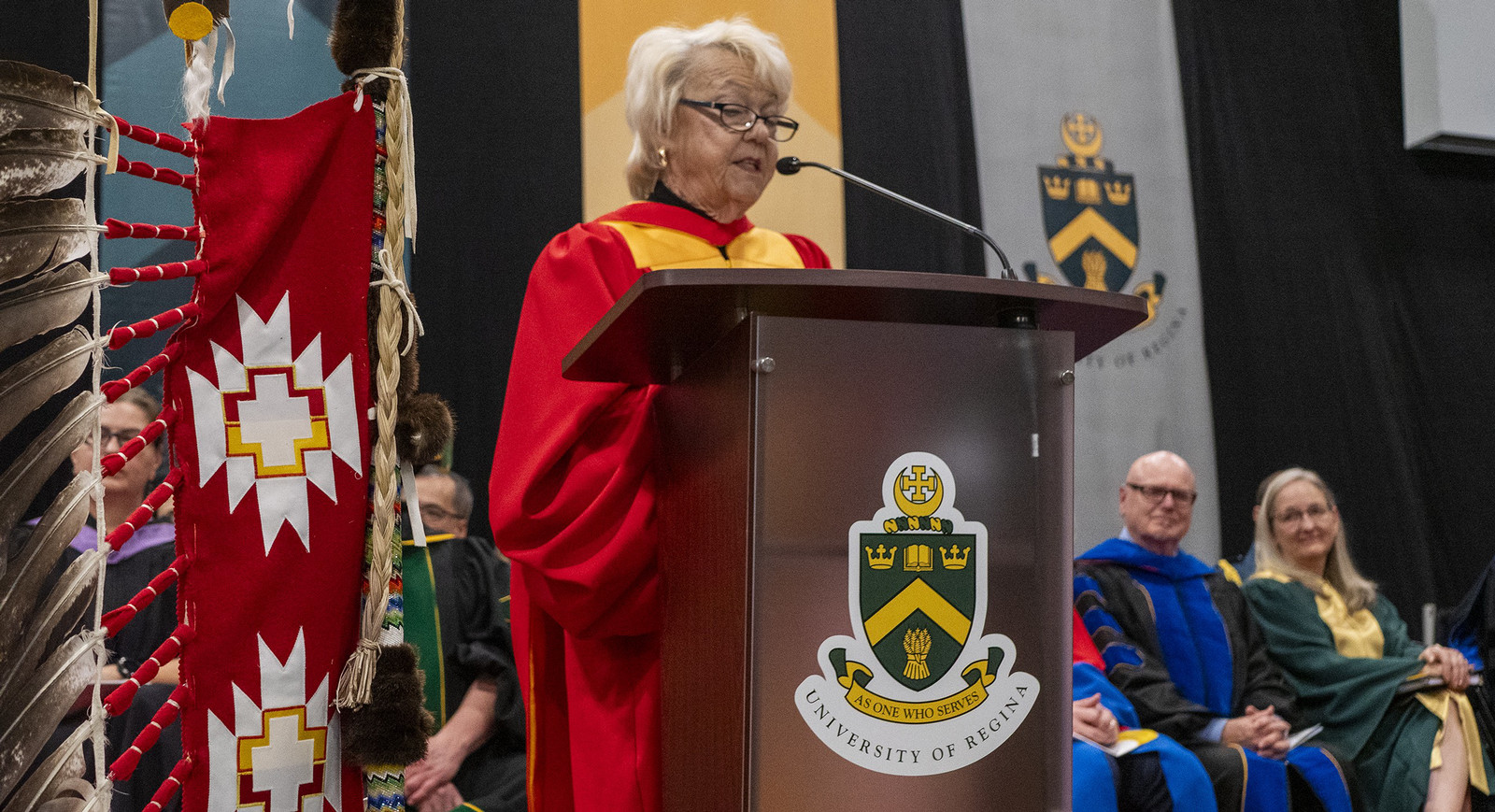 woman in a gown speaking at a podium