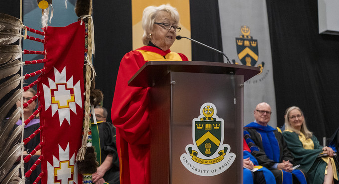 woman in a gown speaking at a podium