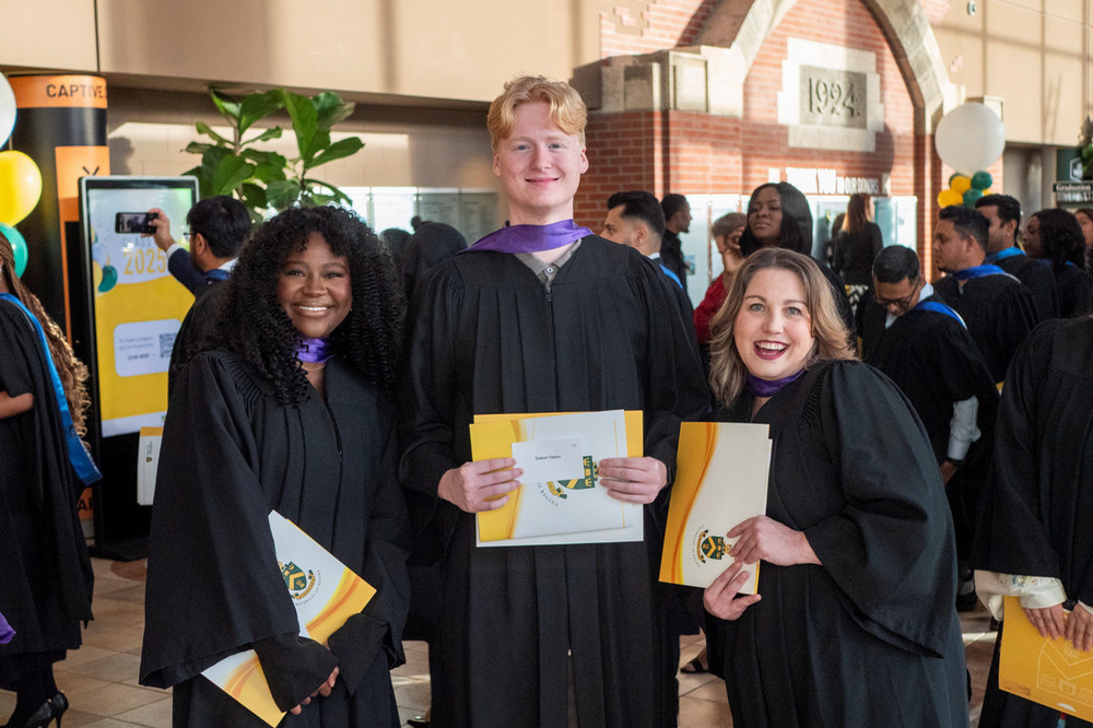 three students posing at convocation