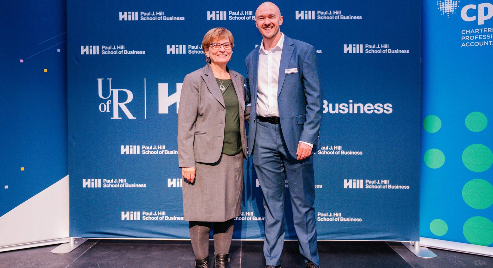 two people standing in front of a large banner