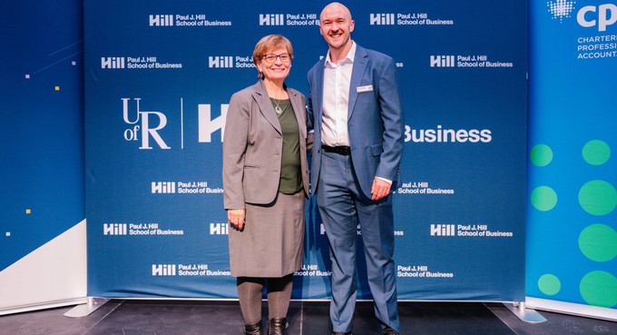 two people standing in front of a large banner