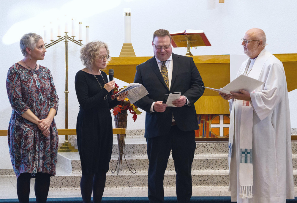four people standing on a church altar