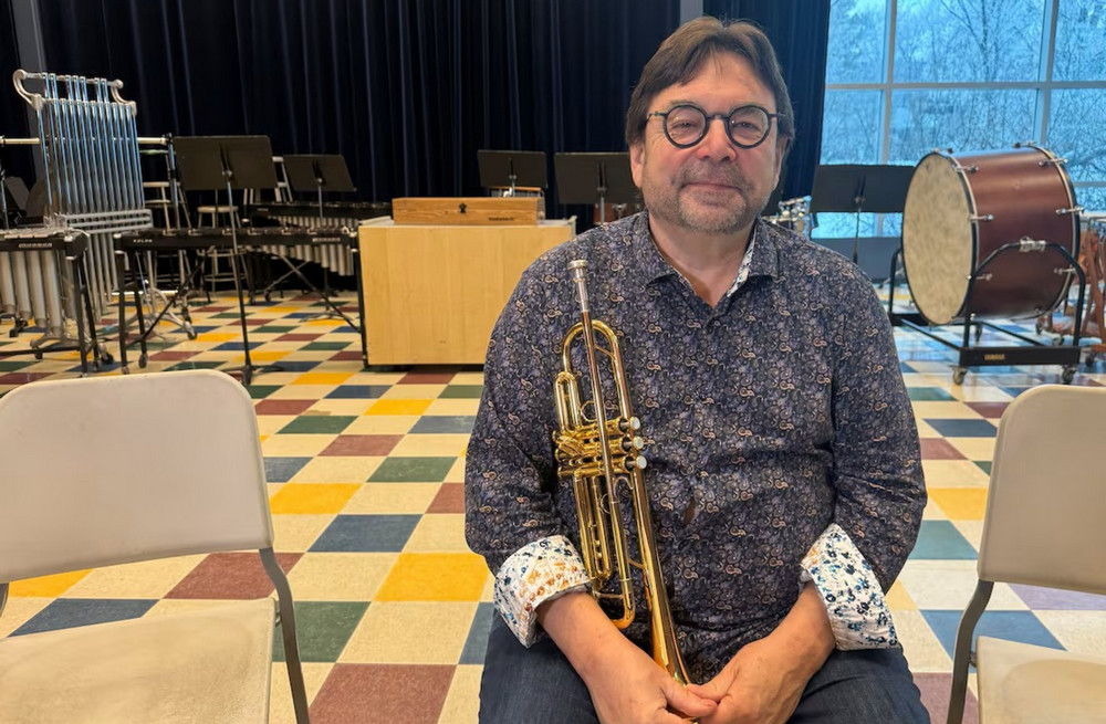 man sitting in a chair holding a trumpet