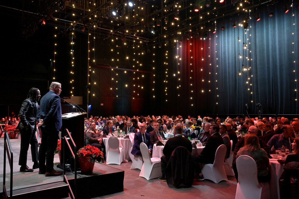 A decorated room with people seated and lights all around.