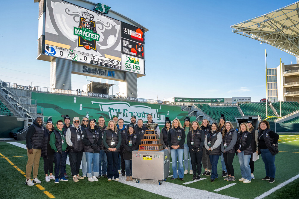 A large group of people standing around a trophy